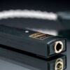 Le DAC portable iFi GO Link posé à côté d'un smartphone pour illustrer sa petite taille.