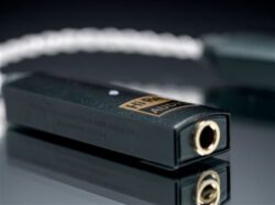 Le DAC portable iFi GO Link posé à côté d'un smartphone pour illustrer sa petite taille.